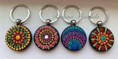 three key chains that have different designs on them, one is colorful and the other has an oval shape