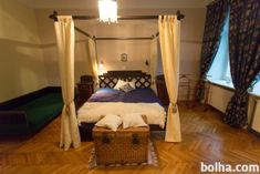 a bed sitting on top of a hard wood floor next to a basket filled with pillows