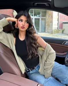 a woman sitting in the back seat of a car