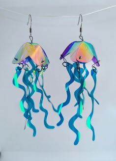 Twotone Jellyfish Earrings  These shimmery cuties are our bestsellers! Playful and vibrant, they sparkle and dance as hard as you do! A variation of the classic, this listing is for a custom made pair in whatever two colors you desire! The primary color will be applied to the body, the secondary color will be the tendrils. Length: approx 13cm (including earring hook) Width approx 3.5cm Price is for a pair (message me about mix and match colors/single earrings) Earring hooks are nickel free and h Handmade Iridescent Earrings For Party, Unique Iridescent Earrings For Party, Whimsical Blue Earrings For Party, Whimsical Iridescent Earrings With Ear Wire, Jellyfish Jewelry, Jellyfish Earrings, Iridescent Earrings, Ocean Earrings, Beach Earrings