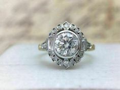 an antique style diamond ring on top of a table