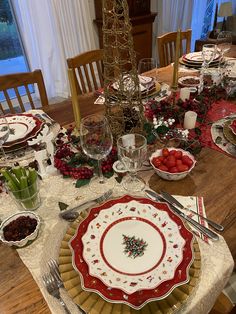 a table set for christmas dinner with plates and silverware