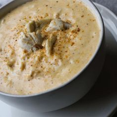 a white bowl filled with soup on top of a plate