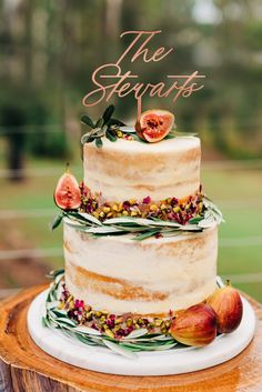 a three tiered cake with figs and flowers on top is featured in this postcard