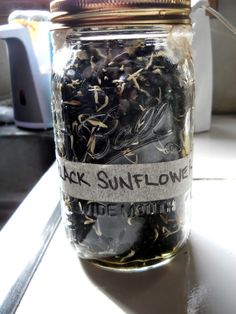 a jar filled with lots of black sunflower seeds