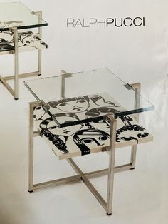 two glass tables with designs on them sitting next to each other