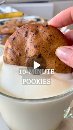 a person is holding a cookie in a bowl