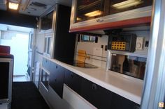 the interior of an rv with black and white cabinets, microwaves and other appliances