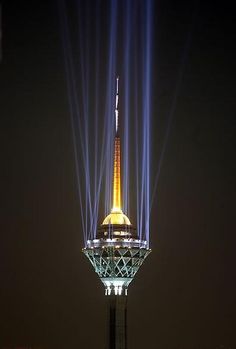 the tower is lit up with blue and yellow lights