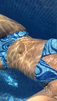 a man in a blue and white swimsuit floating in a pool