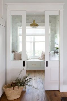 an entryway with white walls and wooden floors