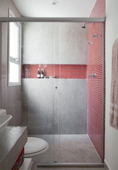 an image of a bathroom with red tile on the walls and shower stall in the middle