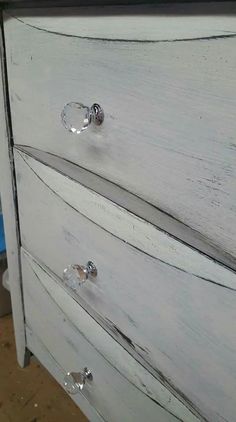 an old white dresser with some knobs on it