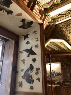 many birds are flying in the air above a doorway and ceiling with ornate designs on it