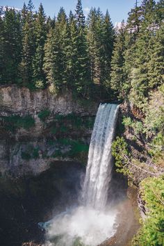 an aerial view of a waterfall surrounded by trees