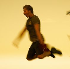 a man is jumping in the air with his legs spread