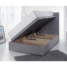 a bed that has been opened and is in the middle of a room with a rug on the floor