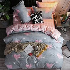 a bed with pink and grey hearts on it