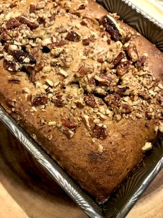 a loaf of bread covered in nuts and raisins on top of a pan