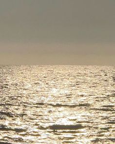 a person riding a surfboard on top of a large body of water at sunset