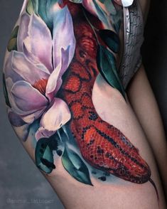 a woman's thigh with flowers and a snake on it