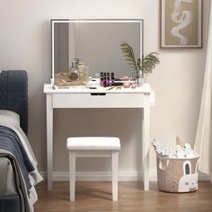 a white vanity table with a mirror and stool in front of it on top of a hard wood floor