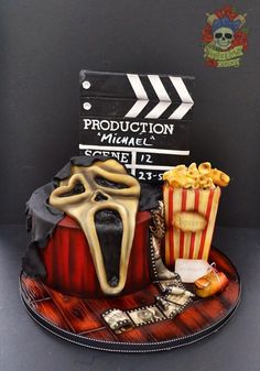 a cake that is shaped to look like a movie set with popcorn and other items