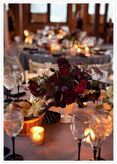 the table is set with wine glasses, candles and flower centerpieces for an elegant dinner