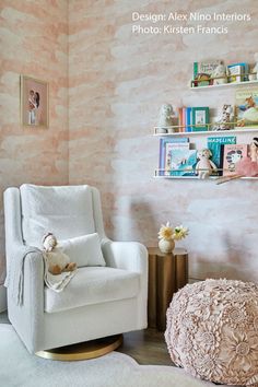 a white chair and ottoman in a room with pink wallpaper on the walls behind it