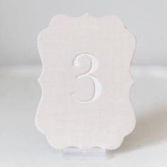 a white table number with the number three on it