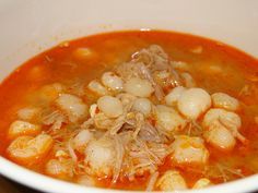 a white bowl filled with shrimp and tomato soup