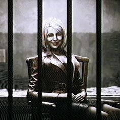 a woman sitting in a chair behind bars