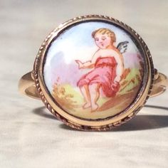 Stunning antique enamel cherub fairy or putti ring. The hand painted enamel cherub is surrounded with a simple rope border, and is has a 9 ct gold stamped gold band.This lovely ring is in a good antique condition and is a possible conversion from an earlier date. The enamel is in a good antique condition  with no chips or cracks to the enamel, and the gold band is good and solid.A stunning antique ring, to add to your jewellery collection.Measures:  Ring size  U.K.  Q    US. nearly 8 1/2 Gold Moonstone Ring, Rope Border, Opal Ring Gold, Antique Ring, Antique Boxes, Lovely Ring, Art Deco Diamond, Antique Art Deco, Moonstone Ring