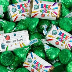 there are many bags of candy wrapped in green foil and have back to school stickers on them