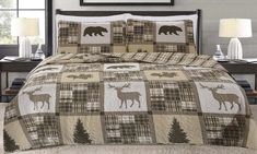 a bed with a moose and pine tree quilt on it