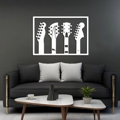 a living room with a couch, coffee table and guitar silhouettes on the wall