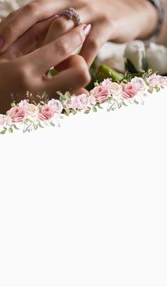 two hands touching each other over a wedding cake with pink flowers on the bottom and white frosting