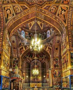 the interior of an ornate church with chandeliers and paintings on the walls,