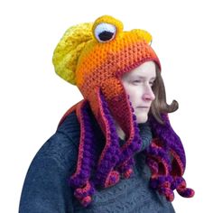 a woman wearing a knitted hat and scarf with an octopus on it's head