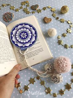 an open book with pom - poms on it next to other decorations and stars