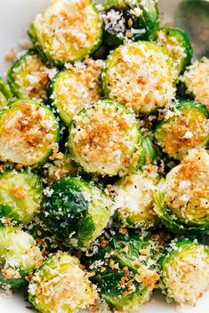 brussel sprouts with parmesan cheese and seasoning in a white bowl