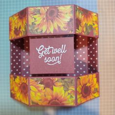 a box with sunflowers painted on it and the words get well soon written in white