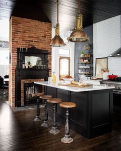 a kitchen with an oven, stove and bar stools in front of the counter