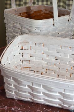 two white baskets sitting on top of a table next to each other, one empty