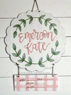 a wooden sign hanging on the side of a white wall next to a pink gingham checkered table cloth