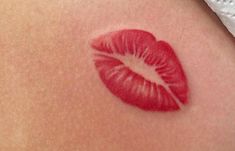 a woman's stomach with a red lip painted on it