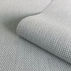 a close up shot of the fabric on a bed sheet that has been made with grey and white herringbones