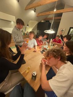 a group of people sitting around a wooden table