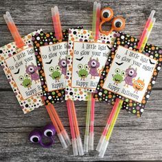 four halloween themed pens and markers on top of a wooden table