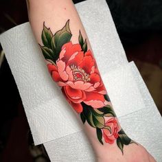 a woman's arm with red flowers on it